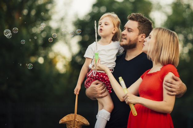 family-blowing-soap-bubbles-outdoors_23-2148222916